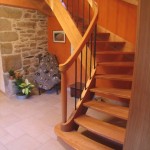 Escalier à courbes massives (chêne), barreaux patinés rouillés, volute de départ.