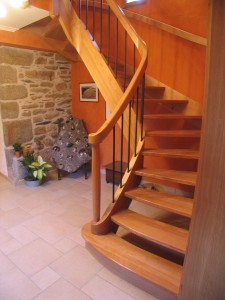 Escalier à courbes massives (chêne), barreaux patinés rouillés, volute de départ.