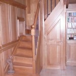 Escalier à noyau integré dans une boiserie assemblée, chêne vernis