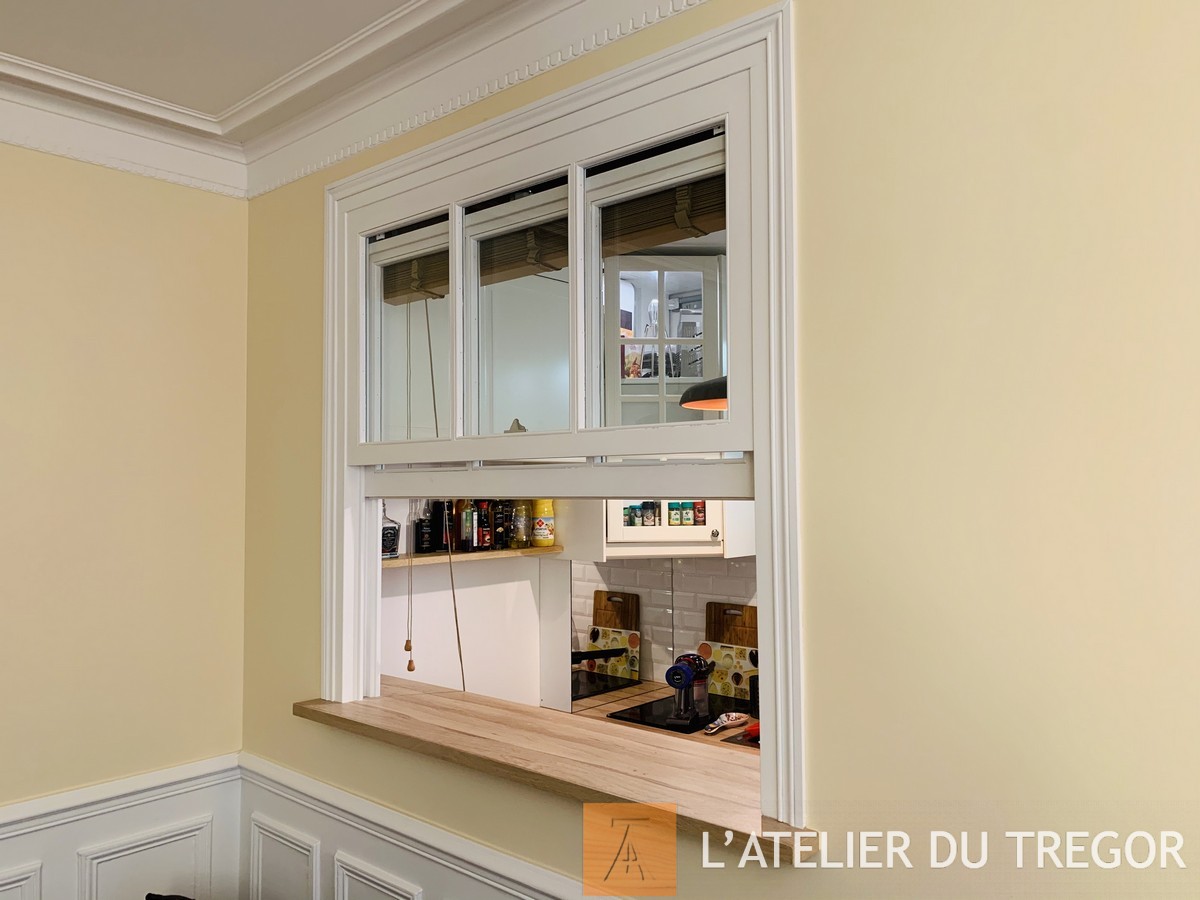 Verrière à guillotine en position ouverte — passage entre cuisine et séjour
