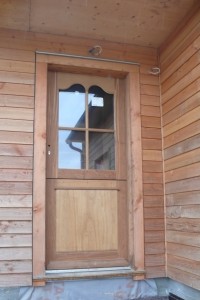 porte d'entrée fermière avec tapées de pose en ossature bois. traverse chantournée
